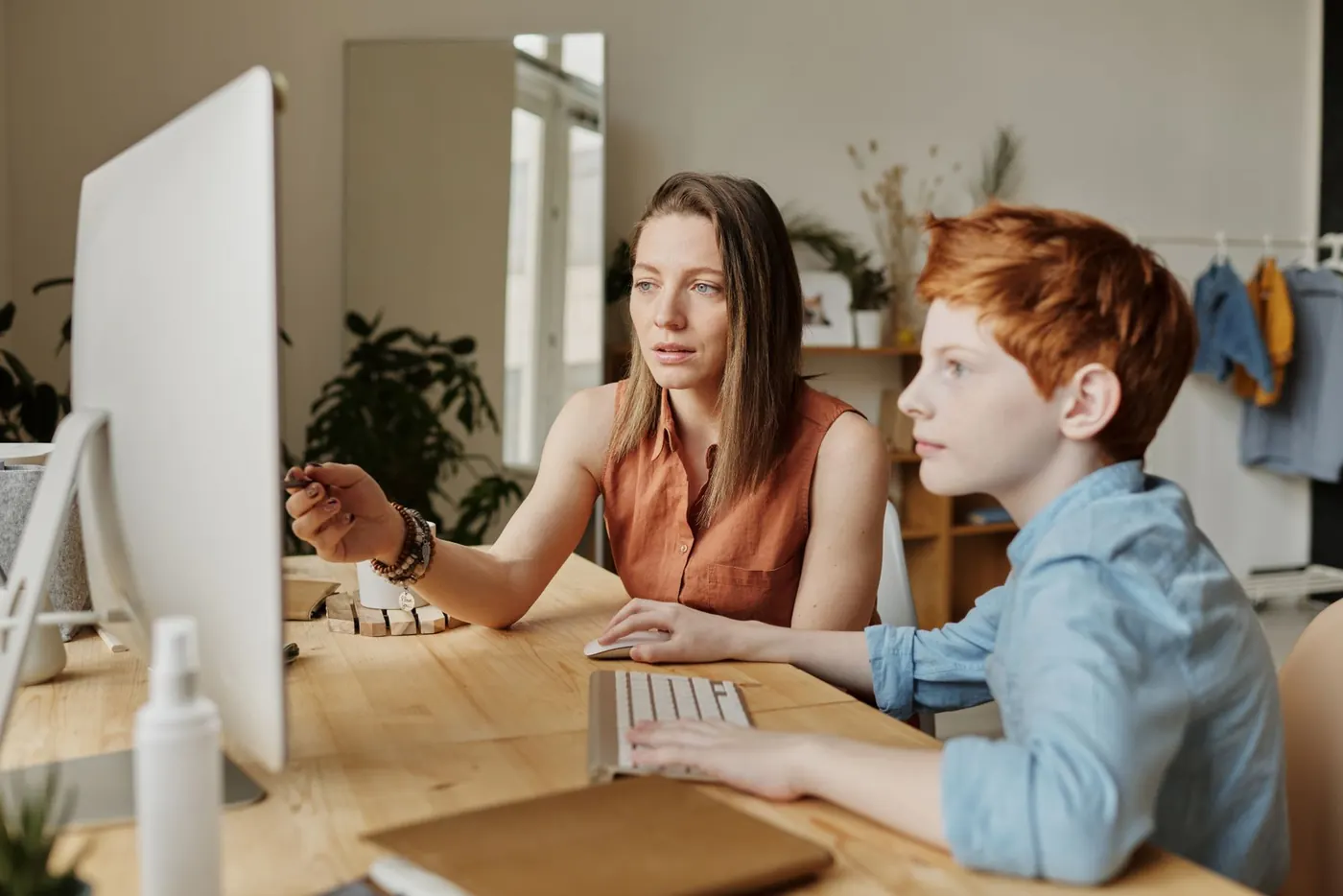 A parent and child using a computer at home. Illustrative stock photography, not customers.